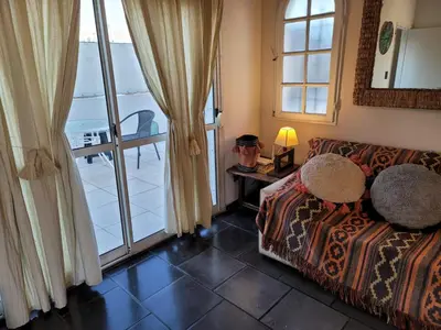 a living room with a couch and a balcony at Córdoba Rent Apart - Mona Suites in Cordoba