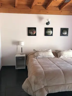 a bedroom with a large bed with three pictures on the wall at Córdoba Rent Apart - Mona Suites in Cordoba