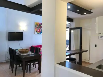 a kitchen and dining room with a table and a television at Córdoba Rent Apart - Mona Suites in Cordoba