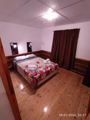 a bedroom with a bed and a wooden floor at La Cautiva 225 in Villa del Dique