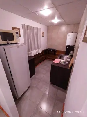 a small kitchen with a refrigerator and a table at La Cautiva 225 in Villa del Dique