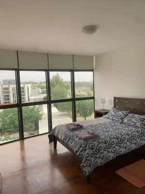 a bedroom with a bed and a large group of windows at Departamento boutiques, centrico in Villa Carlos Paz