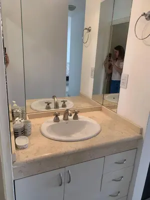 a woman taking a picture of a bathroom sink at Departamento boutiques, centrico in Villa Carlos Paz
