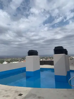 a swimming pool with two white and blue columns at Departamento boutiques, centrico in Villa Carlos Paz