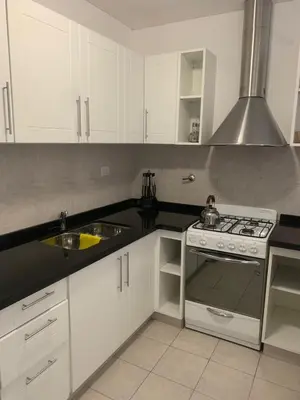 a kitchen with white cabinets and a stove top oven at Departamento boutiques, centrico in Villa Carlos Paz