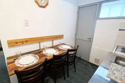 a dining room table with chairs and a clock on the wall at Miniapartamento Ames pleno centro, duermen 4 in Cordoba