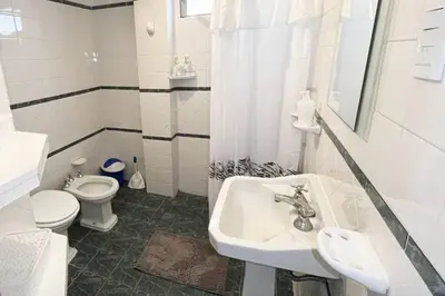 a white bathroom with a sink and a toilet at Miniapartamento Ames pleno centro, duermen 4 in Cordoba