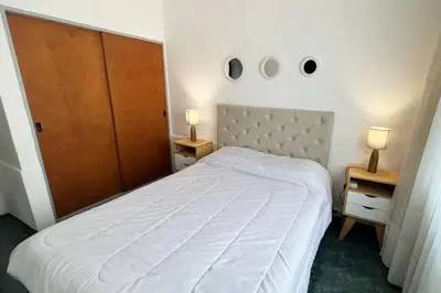 a bedroom with a white bed with two night stands and two lamps at Miniapartamento Ames pleno centro, duermen 4 in Cordoba