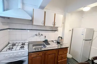 a small kitchen with a stove and a refrigerator at Miniapartamento Ames pleno centro, duermen 4 in Cordoba