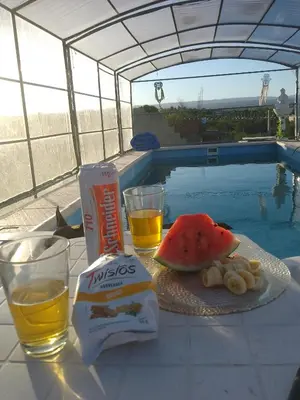 a table with food and drinks next to a swimming pool at Complejo El Bonsai in Villa Santa Cruz del Lago