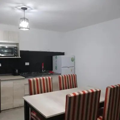 a kitchen with a table and chairs in a kitchen at Complejo El Bonsai in Villa Santa Cruz del Lago