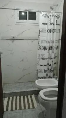 a bathroom with a toilet and a shower curtain at Complejo El Bonsai in Villa Santa Cruz del Lago