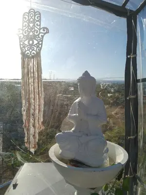 a statue sitting on top of a window with a cross at Complejo El Bonsai in Villa Santa Cruz del Lago