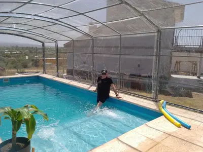 a man is standing in a swimming pool at Complejo El Bonsai in Villa Santa Cruz del Lago