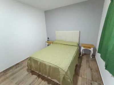 a small bedroom with a bed and a table at Barranca Poceña in Quebrada de los Pozos