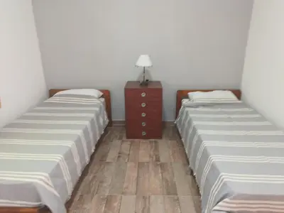 two twin beds in a room with a dresser at Barranca Poceña in Quebrada de los Pozos