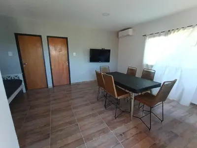 a dining room with a black table and chairs at Barranca Poceña in Quebrada de los Pozos