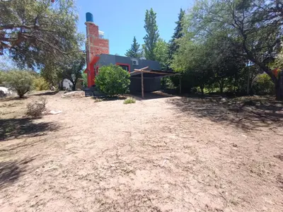 a house in the middle of a dirt field at Barranca Poceña in Quebrada de los Pozos