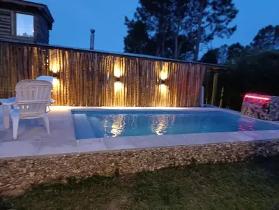 a pool with a chair and a table and a fence at Cabañas lipamai in Potrero de Garay