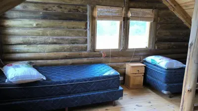a bedroom with two beds in a log cabin at Cabañas lipamai in Potrero de Garay
