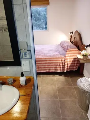 a bathroom with a bed and a sink and a shower at CerroMio! in Villa Serranita