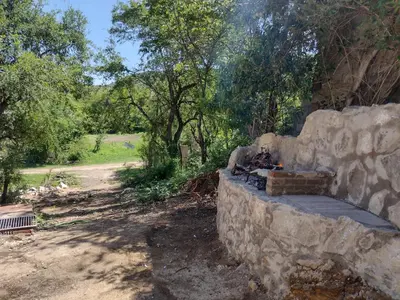 a stone wall with a fireplace in a field at CerroMio! in Villa Serranita