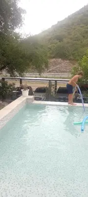 a person in a swimming pool with a water hose at CerroMio! in Villa Serranita