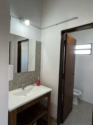 a bathroom with a sink and a mirror and a toilet at EL CHALÉ casa de campo in Mina Clavero
