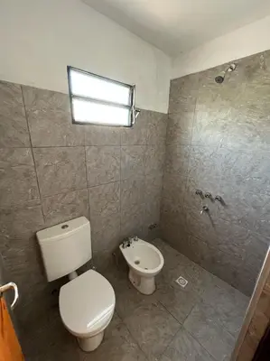 a bathroom with a toilet and a sink at EL CHALÉ casa de campo in Mina Clavero