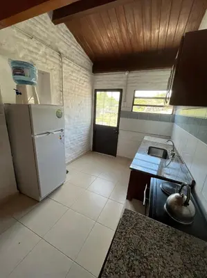a small kitchen with a refrigerator and a sink at EL CHALÉ casa de campo in Mina Clavero