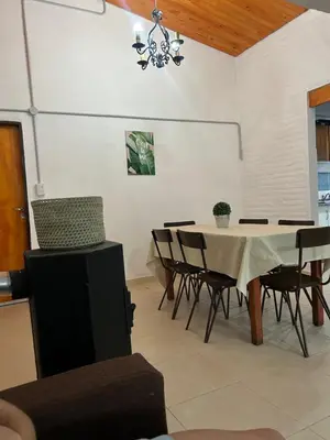 a dining room with a table and chairs and a chandelier at EL CHALÉ casa de campo in Mina Clavero