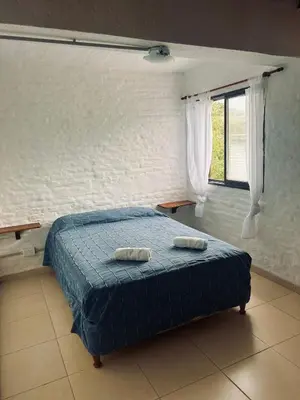 a bedroom with a bed with two towels on it at EL CHALÉ casa de campo in Mina Clavero