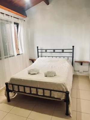a bedroom with a bed with two towels on it at EL CHALÉ casa de campo in Mina Clavero