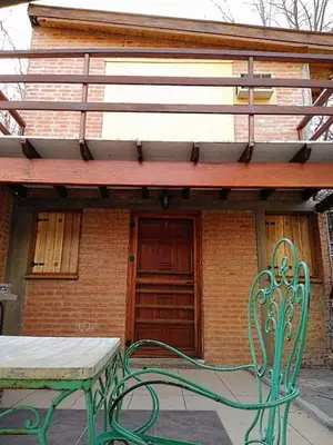a green bench sitting in front of a building at Mina's Apart in Mina Clavero