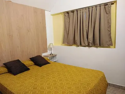 a bedroom with a bed with a yellow bedspread and a window at Mina's Apart in Mina Clavero