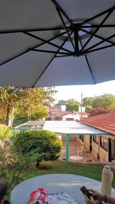 a white umbrella over a table in a yard at Mina's Apart in Mina Clavero
