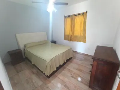 a small bedroom with a bed and a yellow curtain at Complejo Barranca Poceña in Quebrada de los Pozos