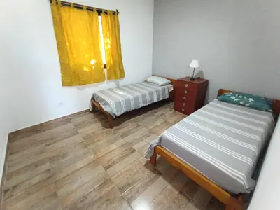 a small room with two beds and a window at Complejo Barranca Poceña in Quebrada de los Pozos