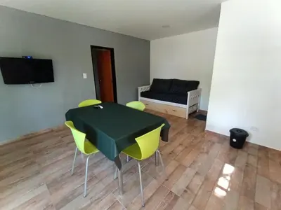 a room with a table and chairs and a bed at Complejo Barranca Poceña in Quebrada de los Pozos