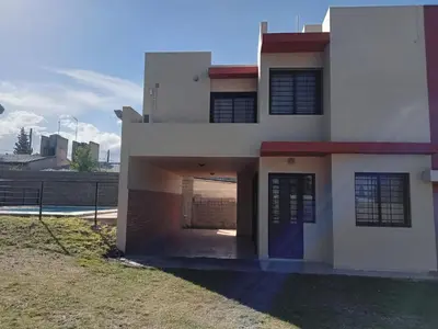 a large white house with a blue door at Mi Chalet Carlos Paz - Dúplex in Villa Santa Cruz del Lago