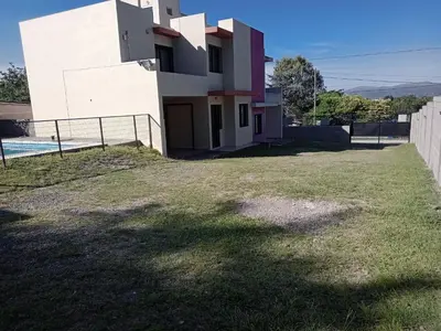 a white house with a fence and a yard at Mi Chalet Carlos Paz - Dúplex in Villa Santa Cruz del Lago