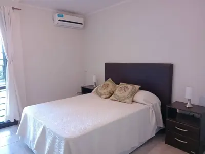 a bedroom with a white bed with two pillows on it at Mi Chalet Carlos Paz - Dúplex in Villa Santa Cruz del Lago