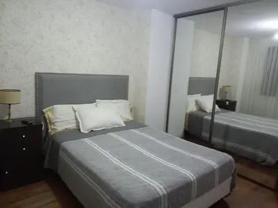 a hotel room with two beds and a mirror at MC departamento in Río Cuarto