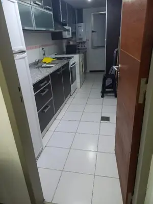 a kitchen with a white tiled floor and cabinets at MC departamento in Río Cuarto