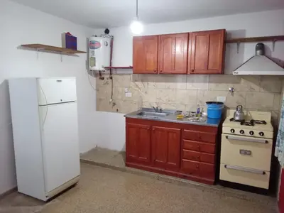 a kitchen with a stove and a white refrigerator at Mi Recreo in Villa Cura Brochero