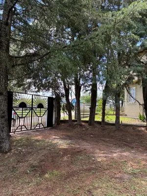 a gate in front of a house with trees at Casa Q a 5km del centro de Villa Carlos Paz in Villa Santa Cruz del Lago