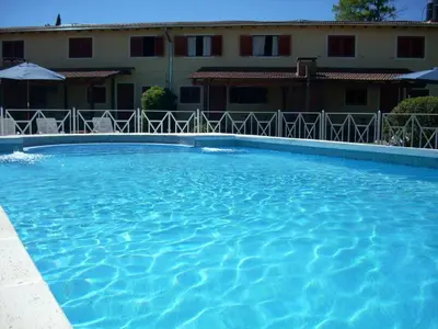 a large blue swimming pool in front of a building at Cantonavi Cabañas in Mina Clavero