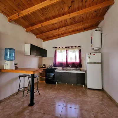 a kitchen with a refrigerator and a table in it at CASA SEN in Mina Clavero