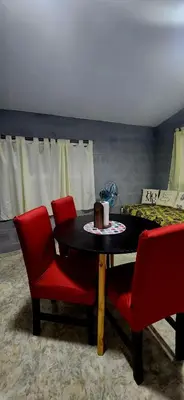 a dining room with a table and red chairs at CASA SEN in Mina Clavero