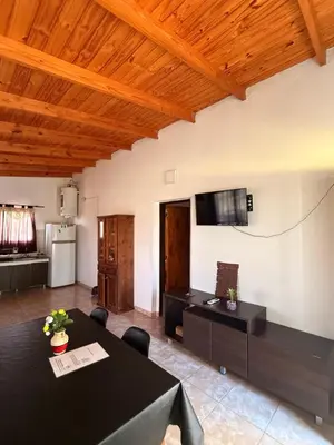 a living room with a table and a tv on the wall at CASA SEN in Mina Clavero